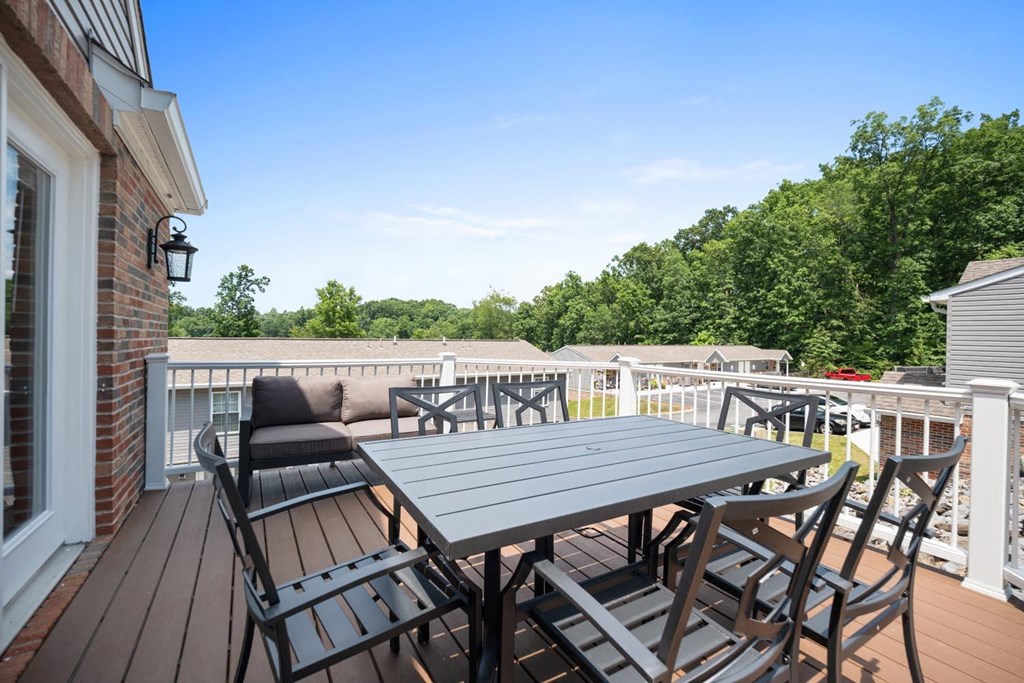 a patio with a table and chairs on a deck