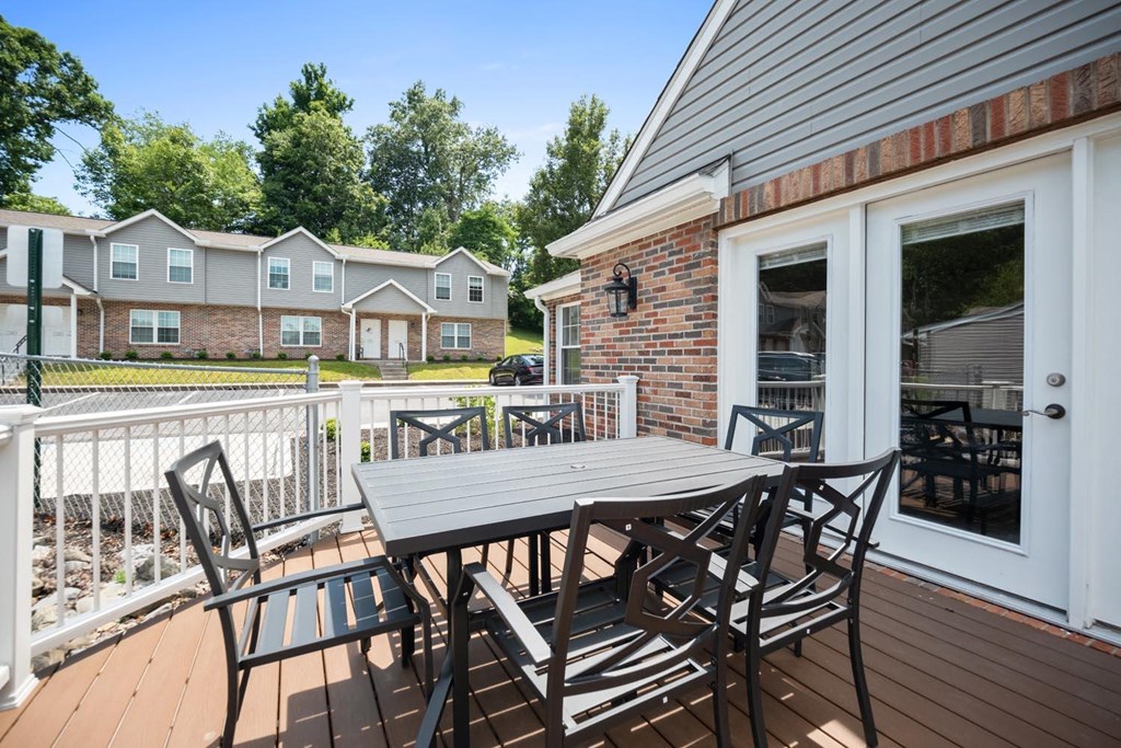 a patio with a table and chairs on a deck