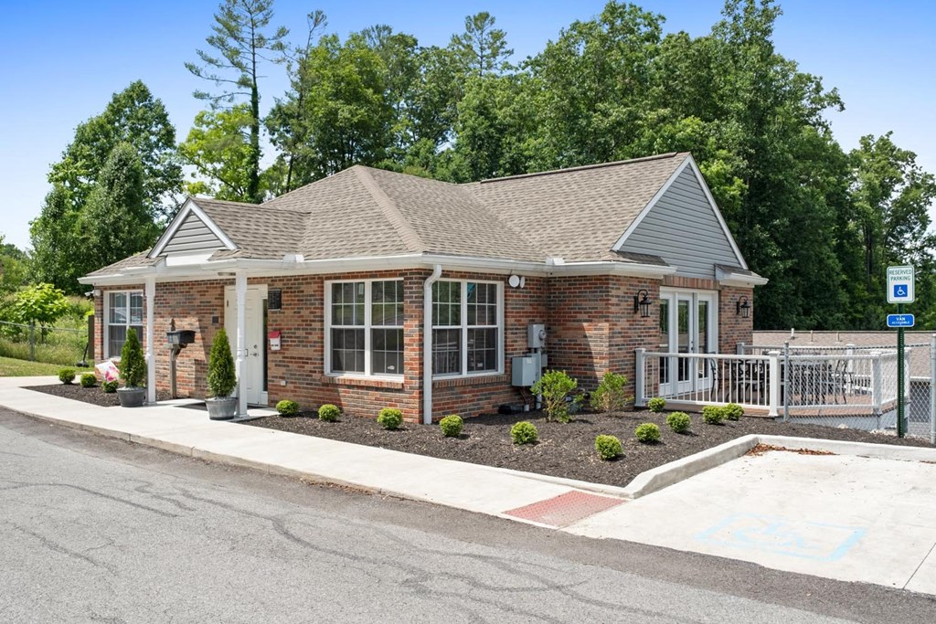 a small brick house with a porch and a driveway