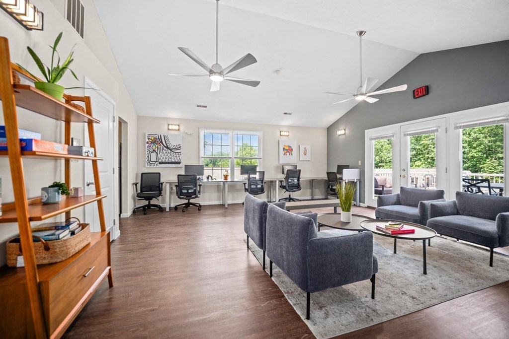 a living room with couches and chairs and large windows