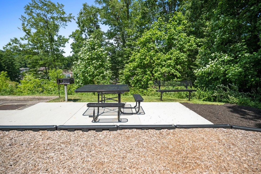 a picnic area with a table and chairs on a platform