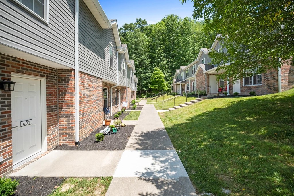 a sidewalk in front of a row of apartment buildings