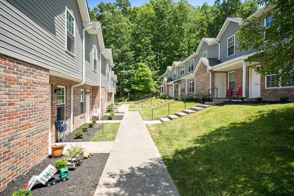 a sidewalk in front of a row of houses