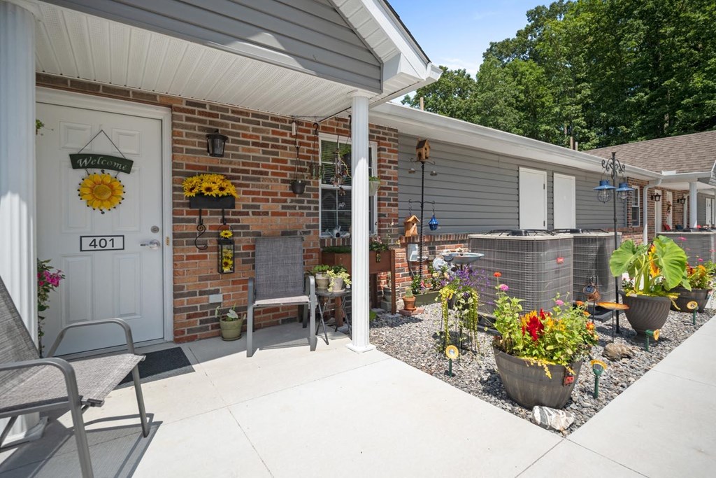 the front porch of a house with a patio and a white door