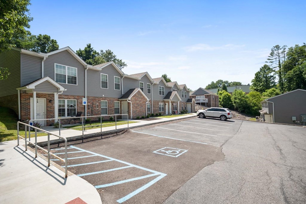 an empty parking lot in front of a row of houses