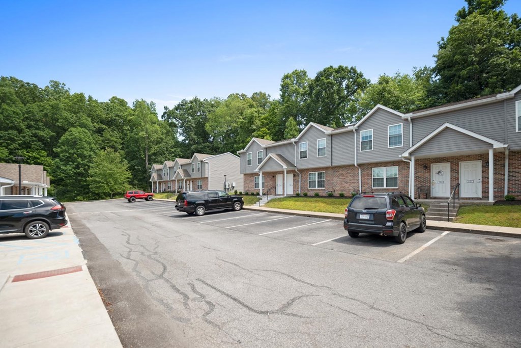 a parking lot with cars parked in front of houses
