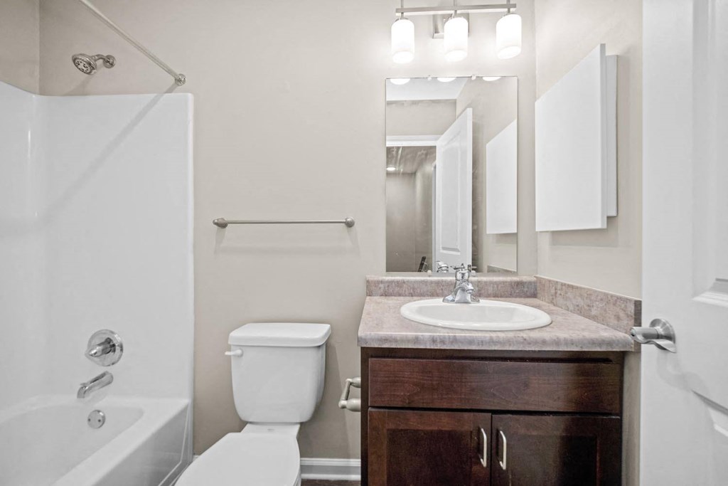 a bathroom with a toilet sink and shower and a mirror