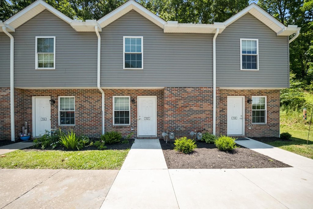 a white house with two white doors and a sidewalk