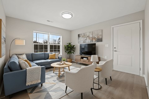 A living room with a blue couch, a coffee table, and a television.