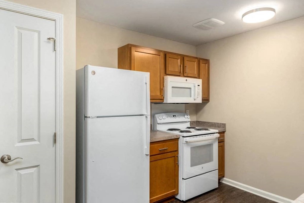 a small kitchen with a white refrigerator and stove