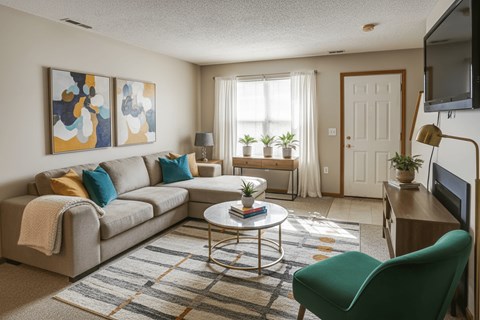 A living room with a grey couch, a green chair, and a coffee table.