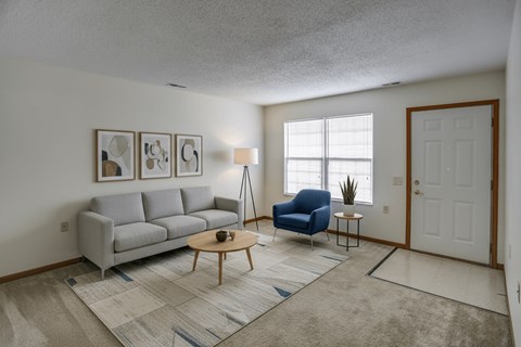 A living room with a grey couch, blue chair, and a coffee table.
