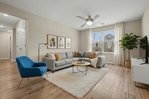 A living room with a blue chair and a grey couch.