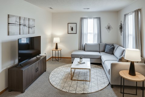 A living room with a grey couch, a television, and a coffee table.