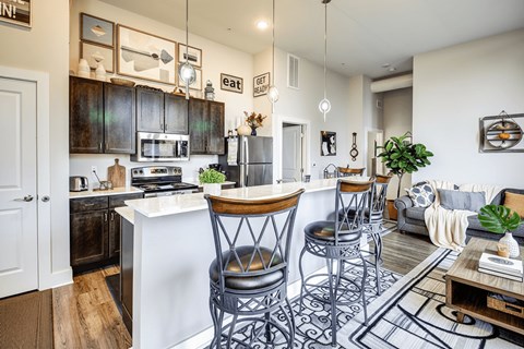 A modern kitchen with a white island and dark wood cabinets.