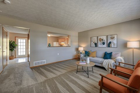 A living room with a couch, chairs, and a coffee table.