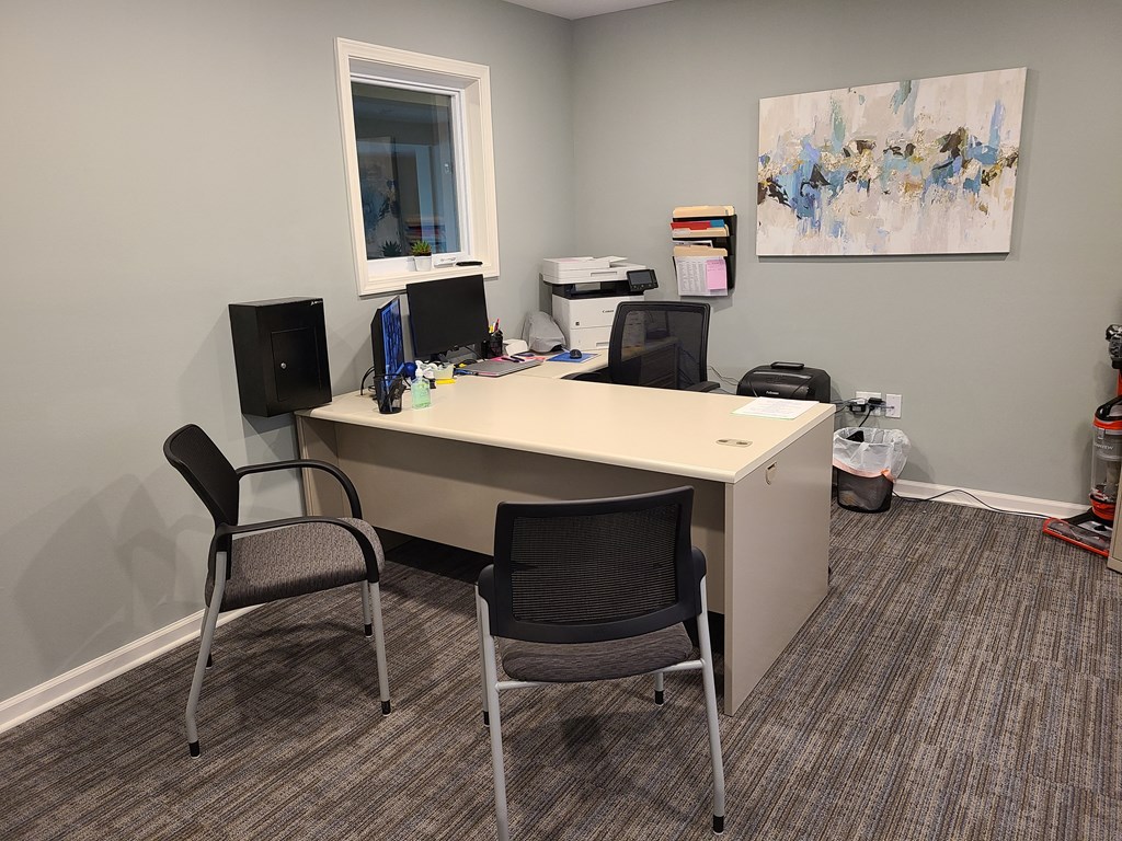 an office with two chairs and a desk with two monitors