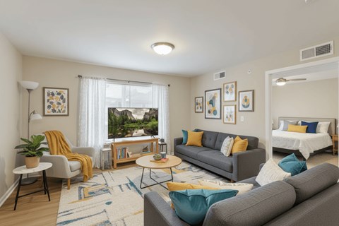 A living room with a grey couch and a yellow chair.
