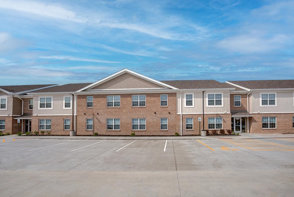 an empty parking lot in front of an apartment building