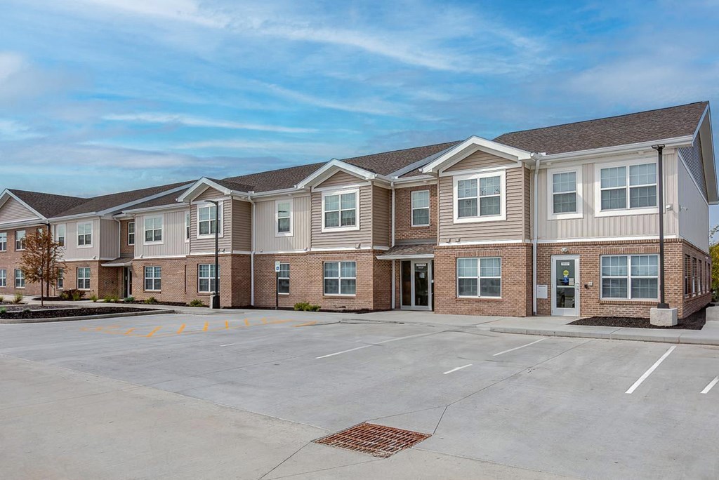 an empty parking lot in front of an apartment building