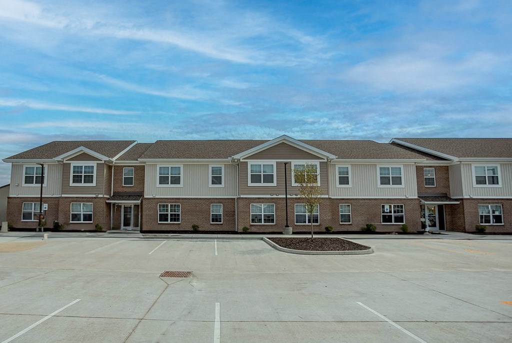 an empty parking lot in front of an apartment building