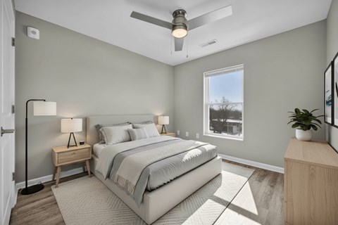 A bedroom with a bed, nightstand, and a ceiling fan.