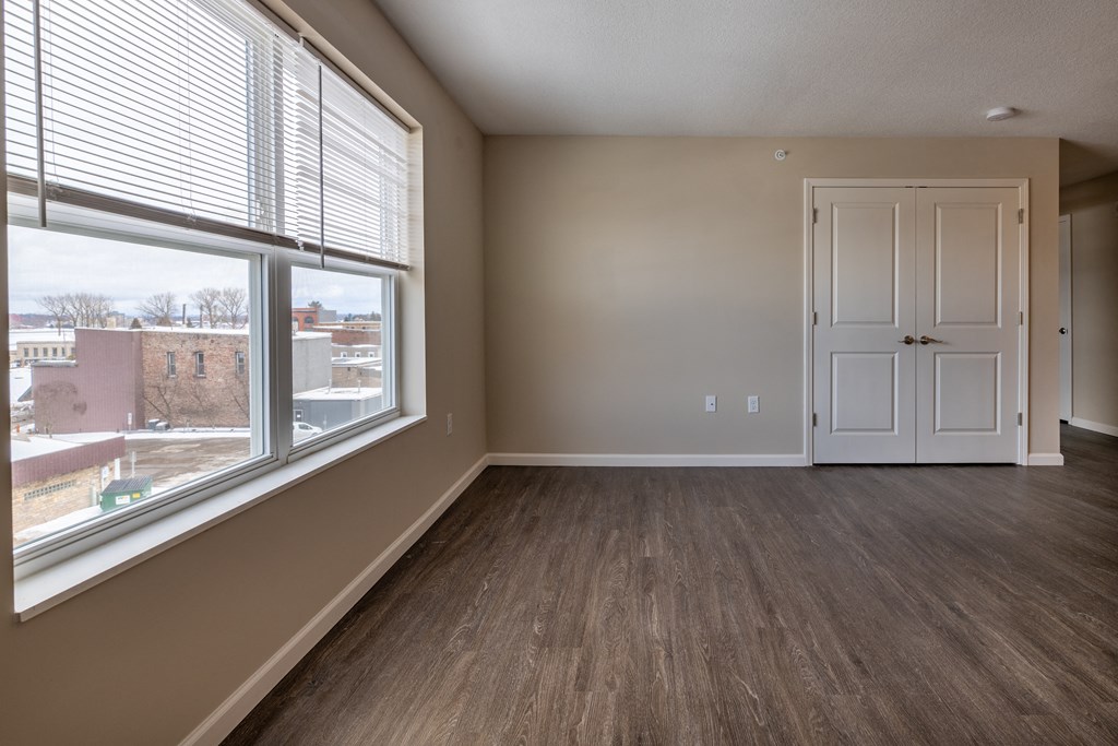 an empty living room with a large window and a door