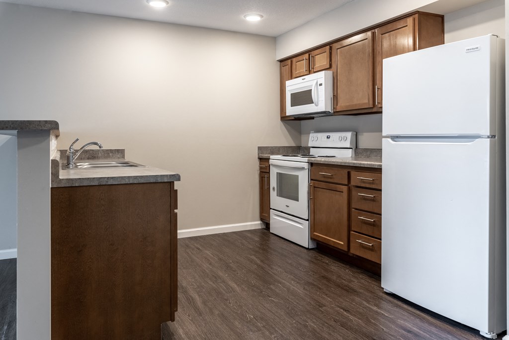 an empty kitchen with a refrigerator and a sink