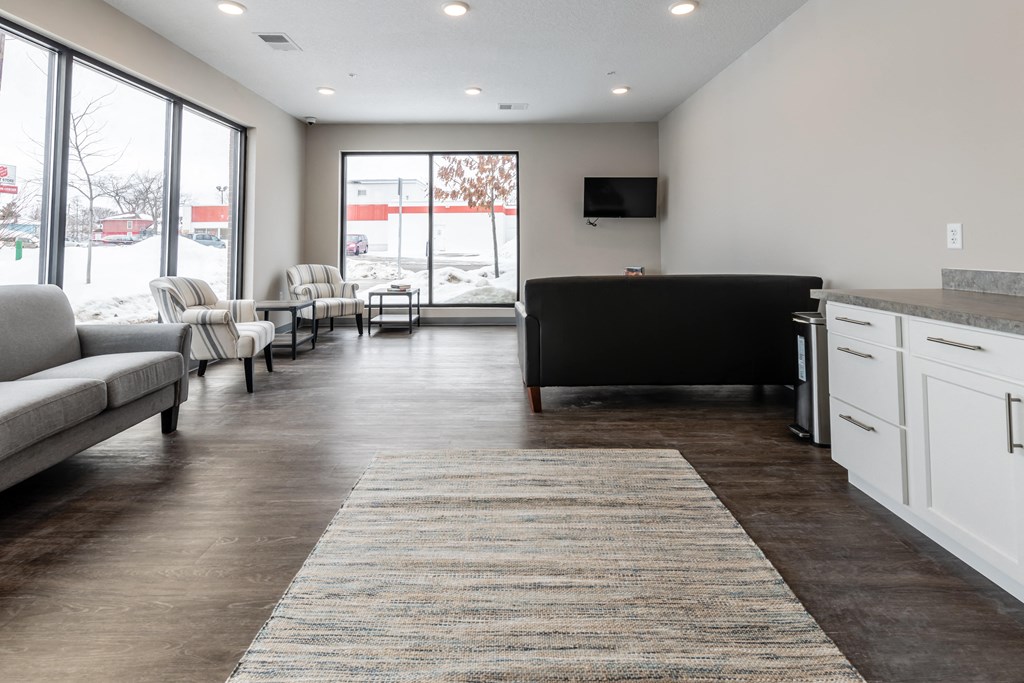 a living room with couches and chairs and a kitchen with a tv