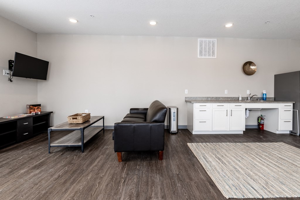 a living room with a couch and a chair and a kitchen