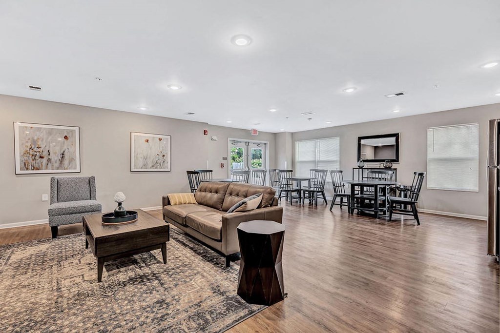 a living room with a couch and a chair in front of a table with chairs and a