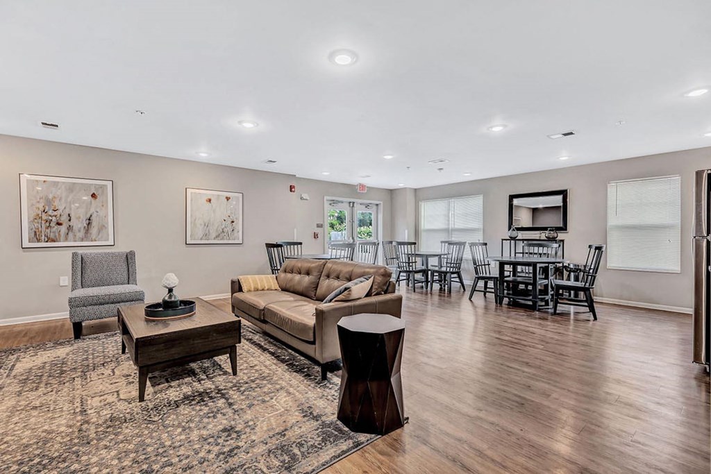 a living room with a couch and a chair in front of a table with chairs and a