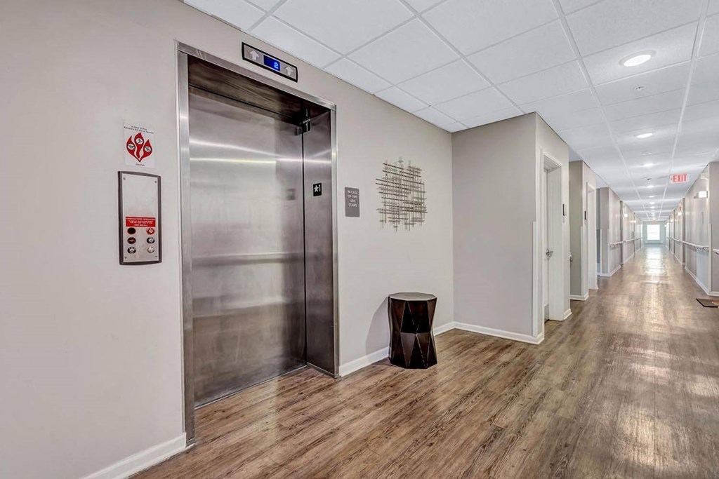 a corridor with a metal door and a stool