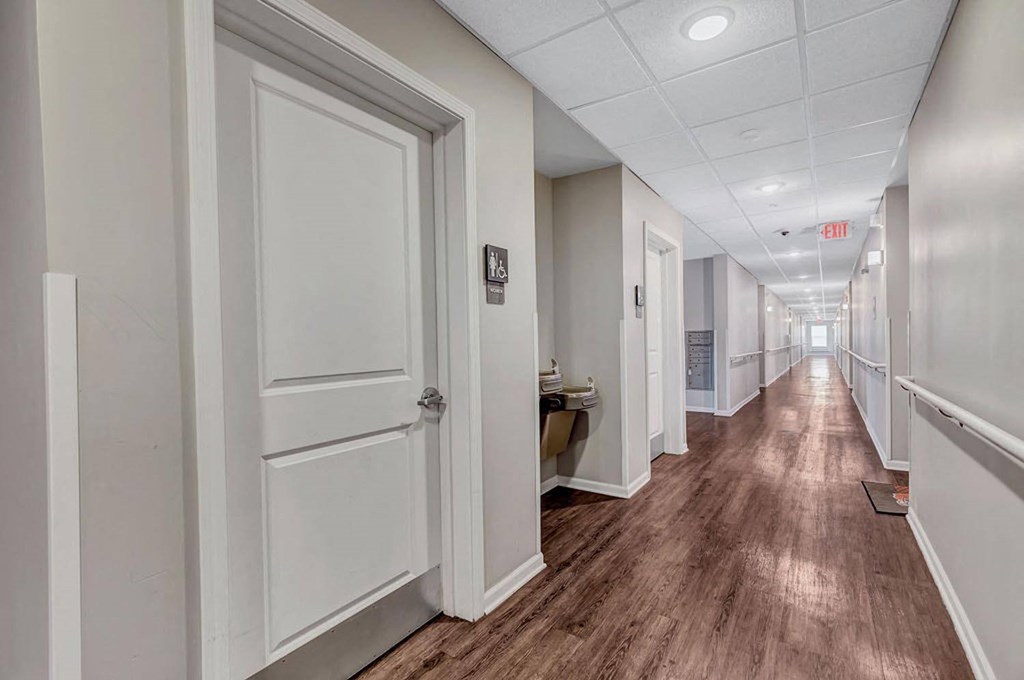 a hallway with white walls and wood floors