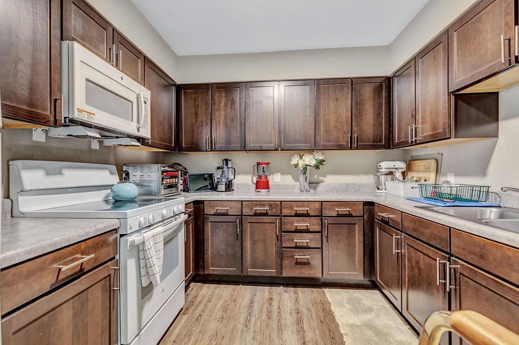 a kitchen with dark wood cabinets and white appliances
