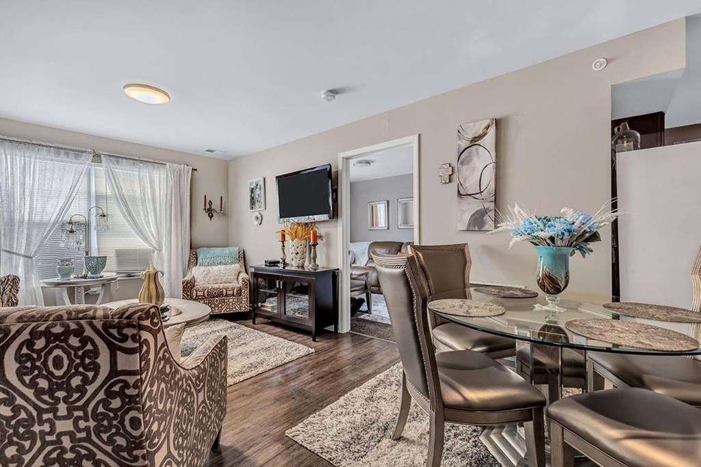 a living room with a table and chairs in front of a tv