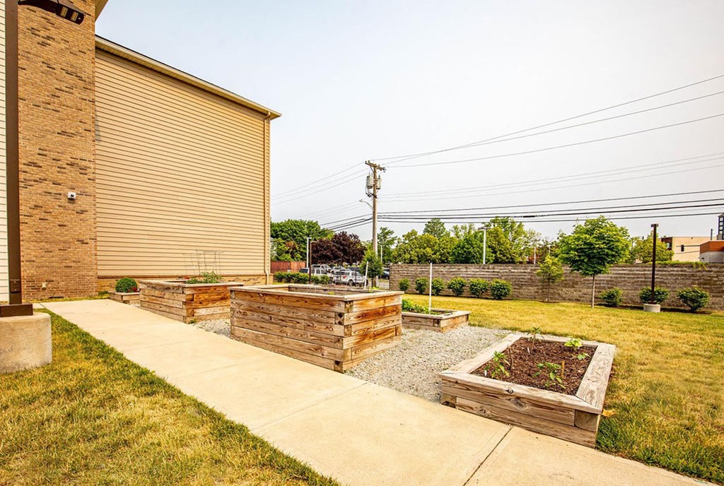 a garden with a brick building on the side of it