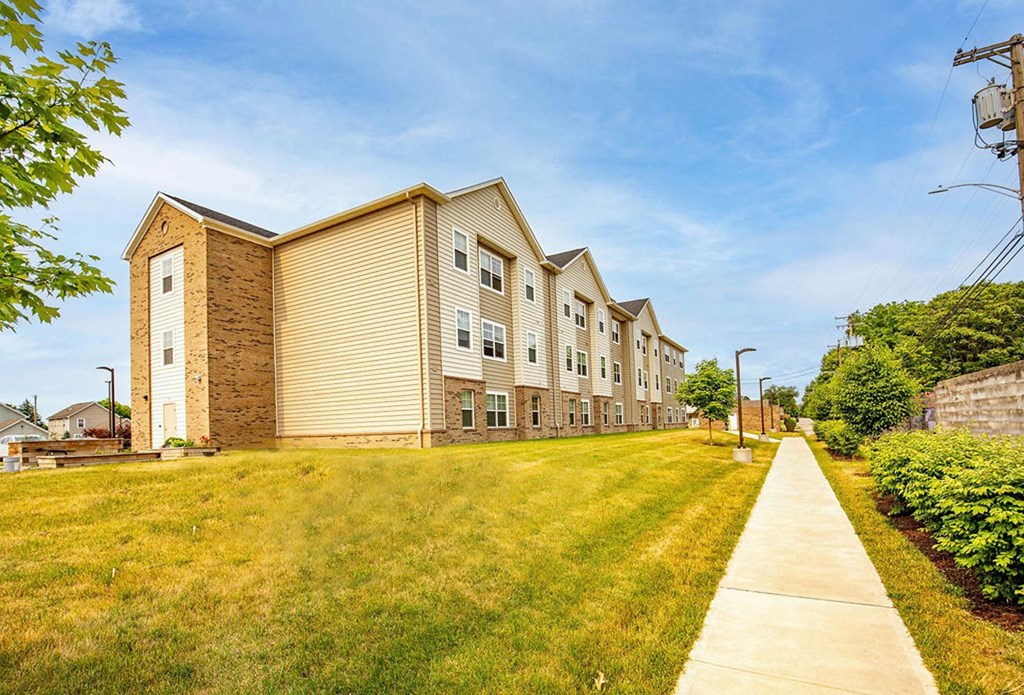 a row of apartment buildings on a grassy hill