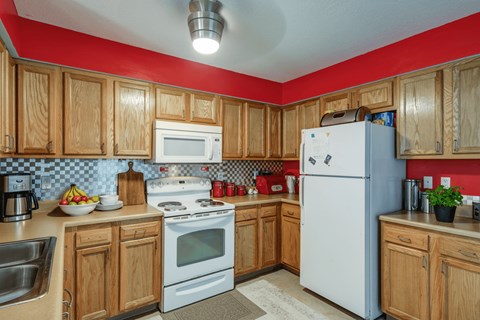 A kitchen with wooden cabinets and a white refrigerator.
