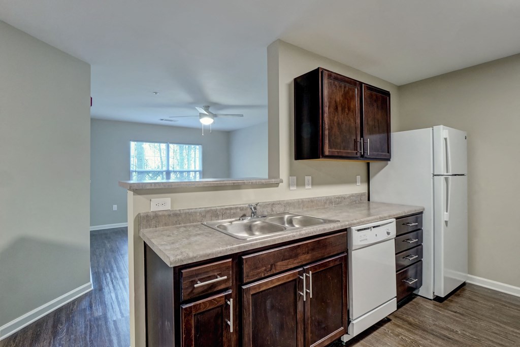 an empty kitchen with a sink and a refrigerator