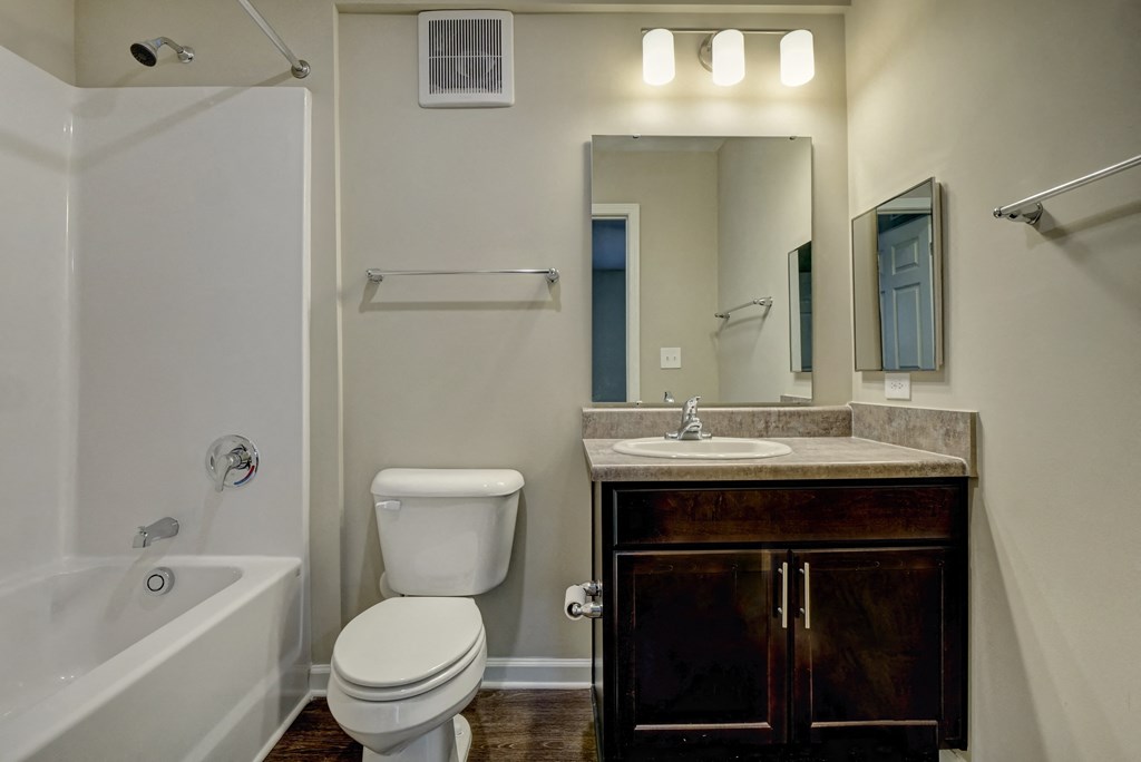 a bathroom with a toilet sink and tub and a mirror