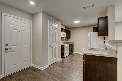 a kitchen with white doors and a sink and a refrigerator
