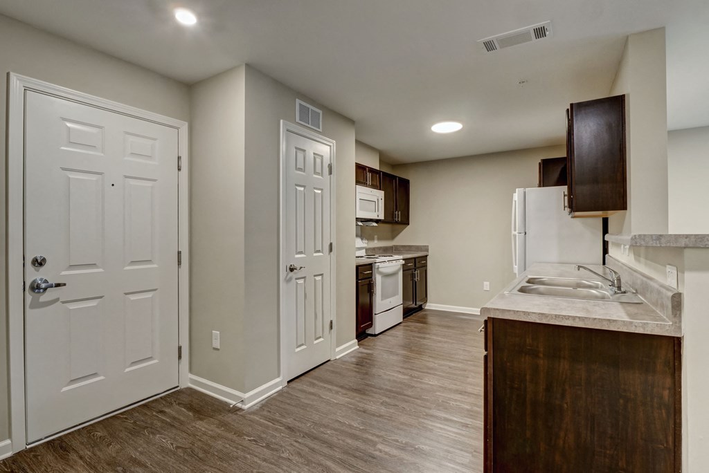 a kitchen with white doors and a sink and a refrigerator