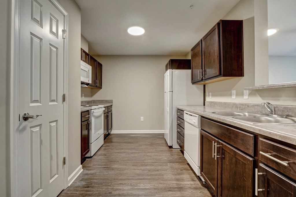 a kitchen with white appliances and wooden cabinets