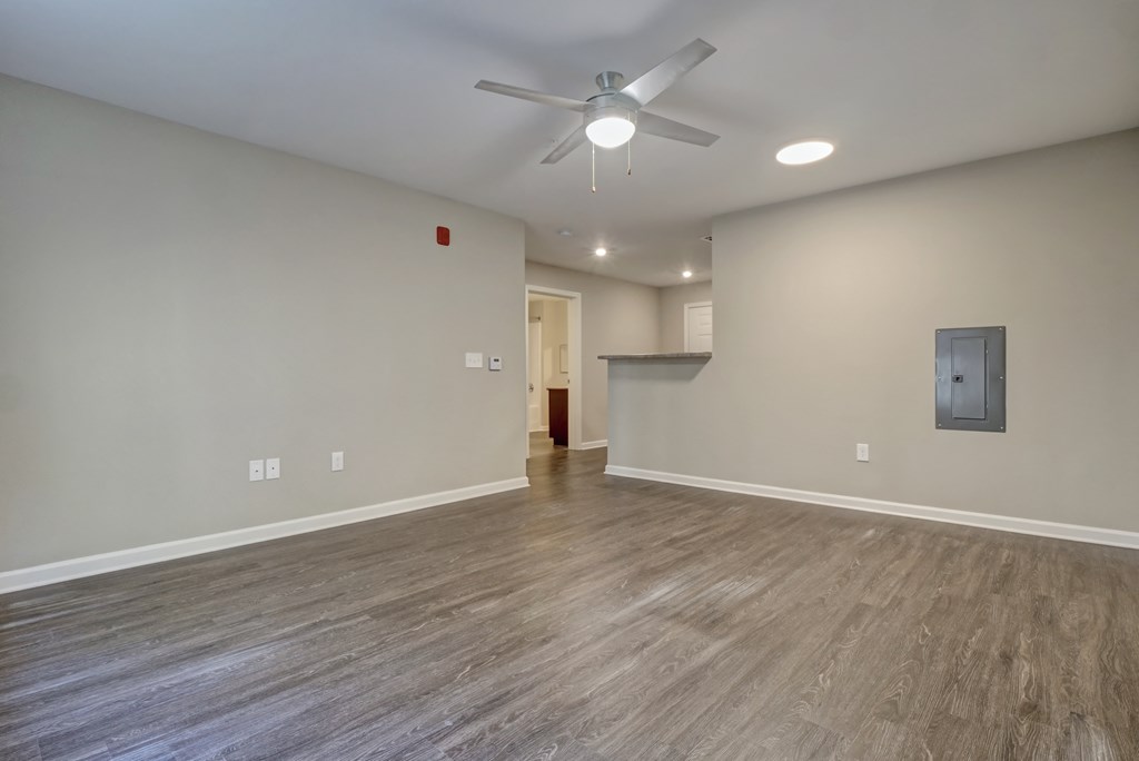 the living room is empty and has a ceiling fan