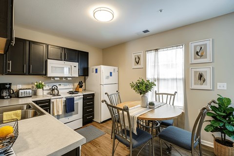 A kitchen with a table and chairs.
