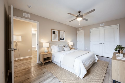 A bedroom with a large bed and a ceiling fan.