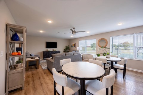 A well-lit living room with a dining table and chairs.