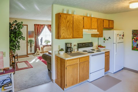 A kitchen with wooden cabinets and a white refrigerator.
