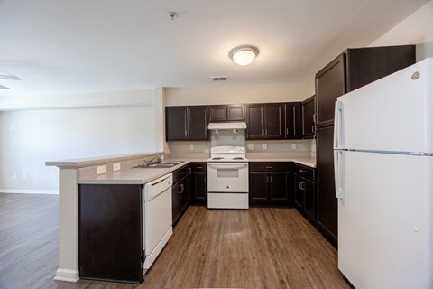A kitchen with black cabinets and white appliances.